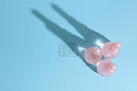 Vaginal enemas on blue background. Women's health. Top view with shadow