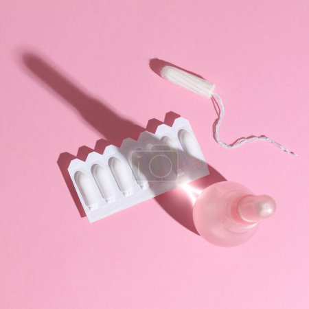 Vaginal enema and suppository, tampon on a pink background. Women's health