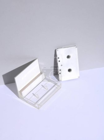 Weiße leere Audio-Kassette im Retro-Stil der 80er Jahre mit Box auf weißem Hintergrund mit Schatten. Kreatives Layout, Mockup, Minimalismus, Musikliebhaber
