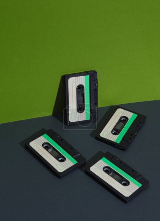 Audio-Kassetten im Retro-Stil der 80er Jahre auf grünem Hintergrund mit Schatten. Kreatives Layout, Minimalismus, Musikliebhaber
