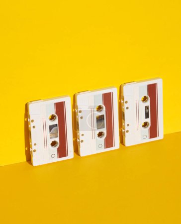 Audio-Kassetten im Retro-Stil der 80er Jahre auf gelbem Hintergrund mit Schatten. Kreatives Layout, Minimalismus, Musikliebhaber