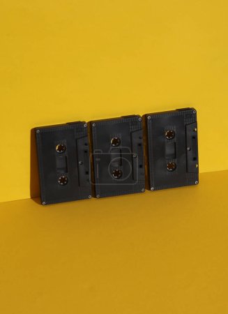 Retro 80s audio cassettes on yellow background with shadow. Creative layout, minimalism, music lover