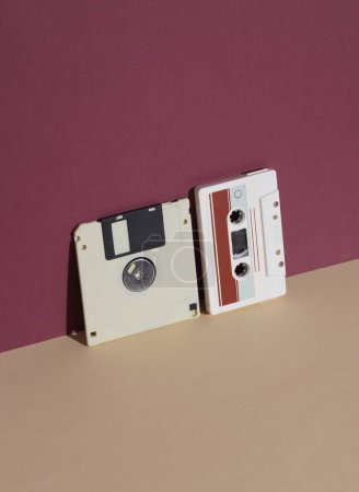 Téléchargez les photos : Disques rétro des années 80 et cassette audio sur fond bordeaux avec ombre. Mise en page créative, minimalisme - en image libre de droit