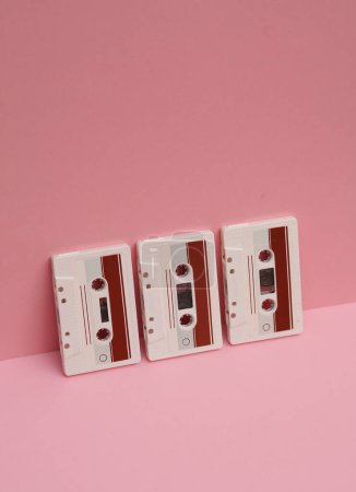 Veraltete Technologien. Audio-Kassetten im Retro-Stil der 80er Jahre auf rosa Hintergrund. Kreative Gestaltung