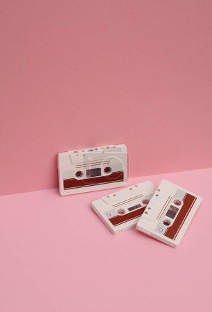 Veraltete Technologien. Audio-Kassetten im Retro-Stil der 80er Jahre auf rosa Hintergrund. Kreative Gestaltung