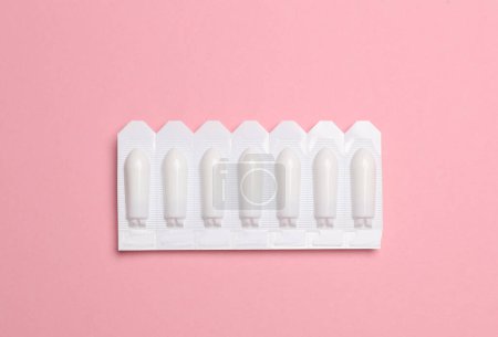 Téléchargez les photos : Plaquettes thermoformées de suppositoires vaginaux sur fond rose - en image libre de droit