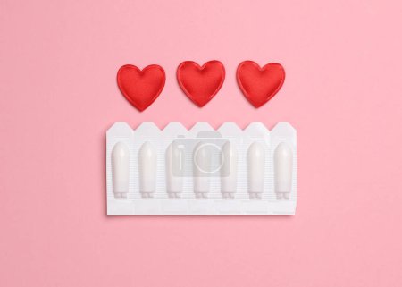 Téléchargez les photos : Plaquettes thermoformées de suppositoires vaginaux, coeurs sur fond rose - en image libre de droit