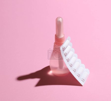 Vaginal enema and suppository on a pink background. Women's health
