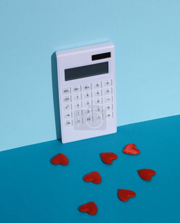 Photo for Hearts with calculator on blue background - Royalty Free Image