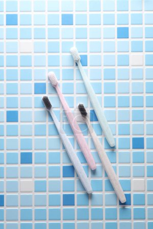 Téléchargez les photos : Brosses à dents en plastique sur une tuile bleue. Vue du dessus - en image libre de droit