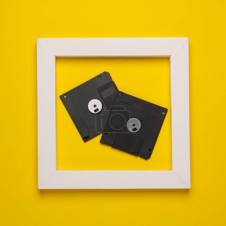 Téléchargez les photos : Disques disquettes rétro en cadre blanc sur fond jaune. Mise en page créative. Minimalisme - en image libre de droit