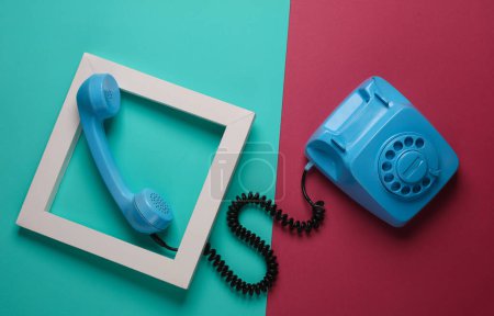 Foto de Teléfono retro giratorio en marco blanco sobre fondo azul rosado. Diseño creativo. Minimalismo - Imagen libre de derechos