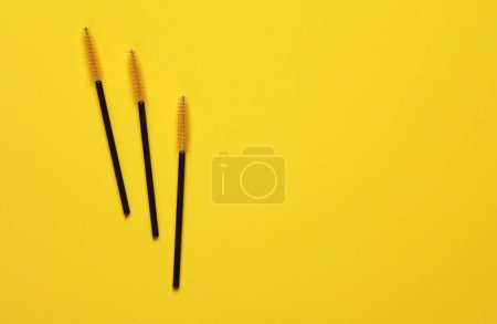 Téléchargez les photos : Brosses pour peigner les cils sur fond jaune. Concept de beauté - en image libre de droit