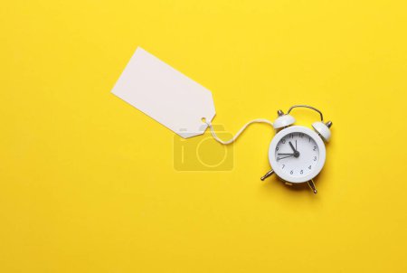 Horloge Aalrm avec étiquette de prix sur fond jaune