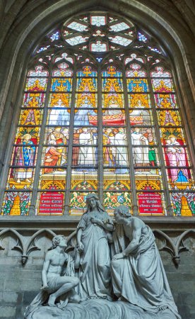 Photo for Brussels, Beigium - September 5, 2018: A sacred marble group in front of a colorful stained glass, on the Saints Michael and Gudule Cathedral - Royalty Free Image