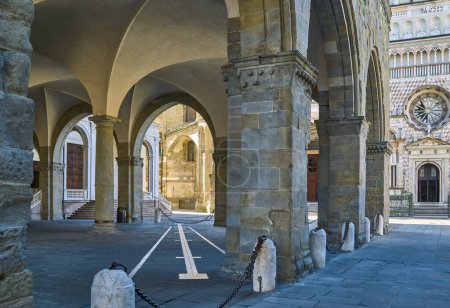 Foto de Italia, Bérgamo, el pórtico de la Palece de la Razón con las iglesias de la plaza de la Catedral en el fondo - Imagen libre de derechos