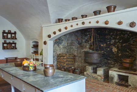 Photo for Manta, Itaky - October 14, 2018: The kitchen with the large fireplace of the sixteenth-century palace of  Valerano Saluzzo Della Manta known as Castello Della Manta - Royalty Free Image