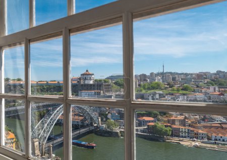 Téléchargez les photos : Porto, Portugal - 18 avril 2023 : Le pont Dom Louis I sur le fleuve Douro avec le monastère Serra do Pilar vu d'une fenêtre du palais épiscopal - en image libre de droit