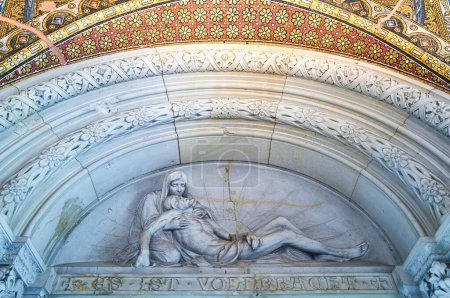 Photo for Berlin, Germany - July 30, 2019: A sacred sculpture above the door to the entrance hall of the Kaiser Wilhelm memorial church, the inscription in German means It Is Finished - Royalty Free Image