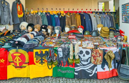 Photo for Berlin, Germany - August 1, 2019: A stall with old uniforms and military symbols from the second world war near the Berlin Wall monument - Royalty Free Image