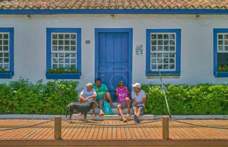 Foto de Buzios, Brasil - 3 de enero de 2023: Un pequeño grupo de habitantes locales en la puerta en el paseo marítimo - Imagen libre de derechos