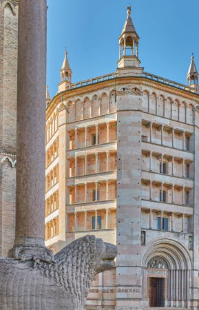 Téléchargez les photos : Parme, Italie, le baptistère octogonal de marbre rose dans le style roman lombard avec un lion de marbre de l'entrée de la cathédrale au premier plan - en image libre de droit