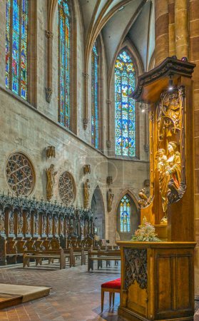 Foto de Colmar, Francia - 21 de septiembre de 2022: El coro de madera con una estatua sagrada en primer plano de la Iglesia Colegiata de San Martín - Imagen libre de derechos