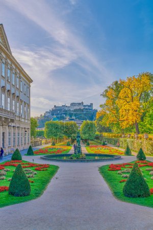 Foto de Salzburgo, Austria - 6 de octubre de 2022: El jardín del palacio Mirabell con el casco antiguo y la fortaleza de Hohenslzburg en el fondo - Imagen libre de derechos