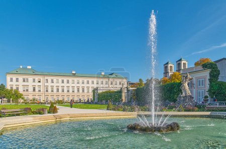 Photo for Salzburg, Austria -  October 6, 2022: The  Mirabell palace and garden's fountain with the St Andrew bell tower in the background - Royalty Free Image