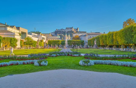 Foto de Salzburgo, Austria - 4 de octubre de 2022: El jardín del palacio Mirabell con el casco antiguo y la fortaleza de Hohenslzburg en el fondo - Imagen libre de derechos