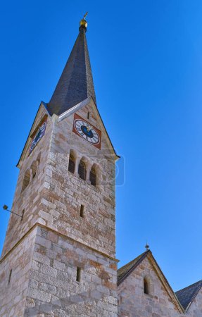 Photo for Halstatt, Austria, upward view of the bell tower of the Evangelical church in the village - Royalty Free Image
