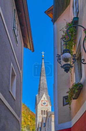 Photo for Hallstatt, Austria, the bell tower of the Evangelical church seen from an alley of the village - Royalty Free Image