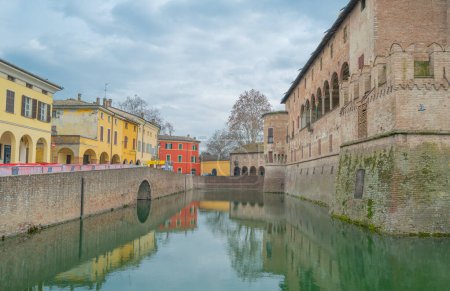 Téléchargez les photos : Fontanellato, Italie - 25 février 2023 : Vue latérale de la forteresse médiévale de Sanvitale avec les maisons colorées du village - en image libre de droit