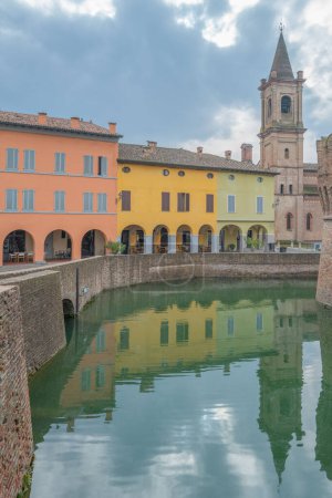 Fontanellato, Italy, reflections on the moat of the fortress of the colorful houses of the vollage