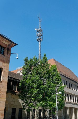 Antennenmast ragt über einen Baum in den Himmel