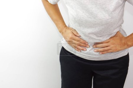 Mujer asiática sufriendo de dolor de estómago. Gastritis crónica, menstruación y concepto de salud.