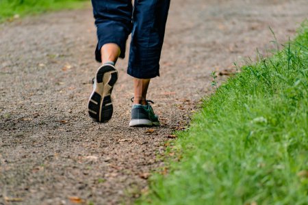 Mujer con zapatillas de correr caminando por un sendero, actividad helada para hacer ejercicio