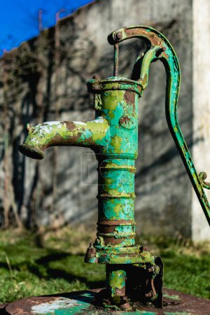 Bomba de agua de mano vieja en un pozo en el jardín, riego y ahorro de agua, medio ambiente rural