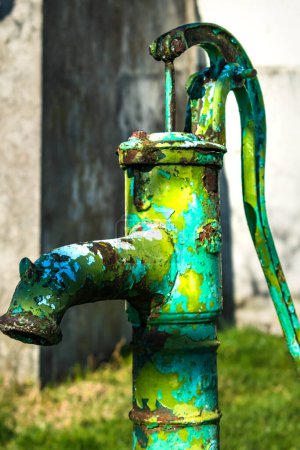 Alte Handwasserpumpe am Brunnen im Garten, Bewässerung und Wassersparen, ländliche Umgebung