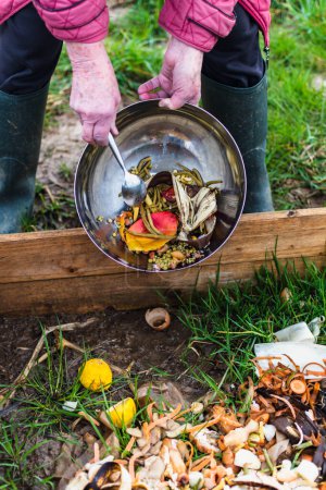 Person who put in a composter some kitchen waste like vegetables, fruits, eggshell, coffee grounds in order to sort and make bio fertilizer