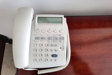 Weißes Telefon auf dem Tisch in einem Hotelzimmer. Nahaufnahme