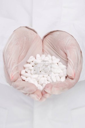 Foto de Medicina, farmacología. Doctor sosteniendo un montón de pastillas - Imagen libre de derechos