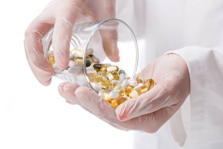 Foto de Medicina, farmacología. Doctor sosteniendo un montón de pastillas - Imagen libre de derechos