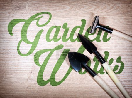 Téléchargez les photos : Miniature gardening tools on wooden background. - en image libre de droit