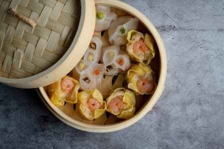Téléchargez les photos : Dim Sum mélange cuit à la vapeur en bambou panier en bois.large gamme de petits plats chinois qui sont traditionnellement appréciés dans les restaurants pour le brunch - en image libre de droit