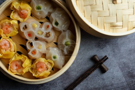 Téléchargez les photos : Dim Sum mélange cuit à la vapeur en bambou panier en bois.large gamme de petits plats chinois qui sont traditionnellement appréciés dans les restaurants pour le brunch - en image libre de droit