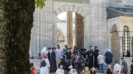 Téléchargez les photos : Porte d'entrée de la mosquée bleue montrant les gens quittent les prières du vendredi. - en image libre de droit