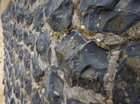 Photo for Black Quarries on wall attached with cement - Royalty Free Image