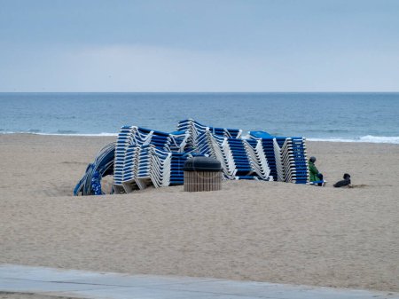 Foto de La Haya, Den Haag. Sillas de playa apiladas al final de la temporada turística en la playa. - Imagen libre de derechos