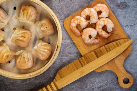 Téléchargez les photos : Dumplings dim sum avec des crevettes farcies en gros plan dans une boîte à vapeur en bambou. - en image libre de droit